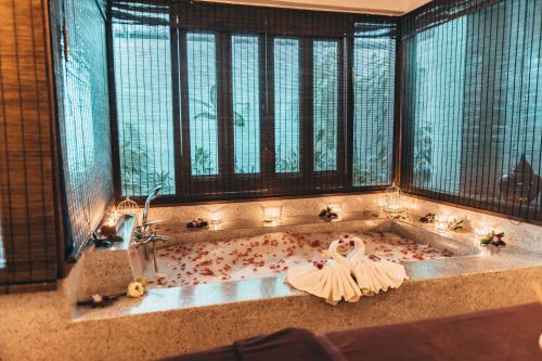 a bride in a bath tub with a bunch of flowers at Sheraton Samui Resort in Chaweng Noi Beach