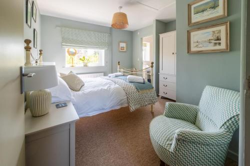 a bedroom with a bed and a chair at Little Tern in Brancaster