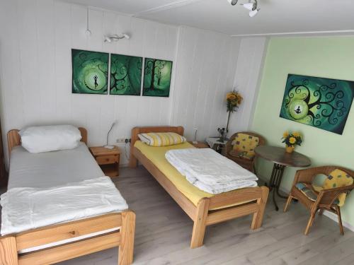 a room with two beds and a table and chairs at Ferienwohnung im Rotkäpchenland in Schwalmstadt