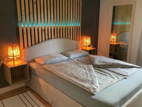 a bedroom with a white bed with two lamps at Moderne Ruheoase Allgäu in Oberreute