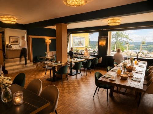a restaurant with tables and chairs and people in the background at Burghotel Volmarstein in Wetter