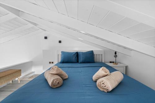 a bedroom with a blue bed with towels on it at Ιπποθόη in Meganisi