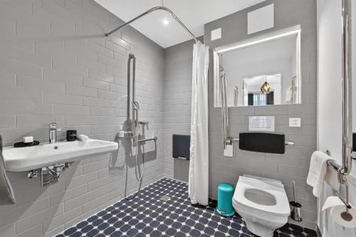 a bathroom with a sink and a toilet and a shower at GLANDON Rooms Haldenhof - Self-Check-In in Lucerne
