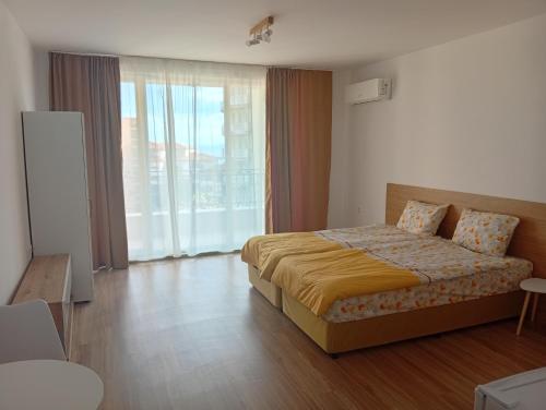 a hotel room with a bed and a large window at Kristan in Sveti Vlas