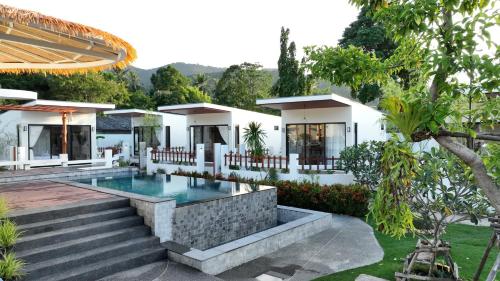 a villa with a swimming pool and a house at Pukawa Hotel & Residence in Chaloklum