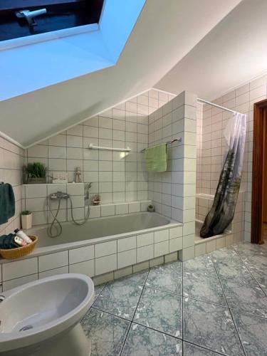 a bathroom with a bath tub and a sink at Lila Central Apartman in Balatonlelle