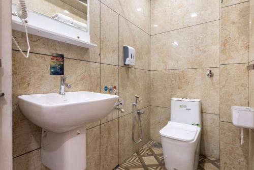 a bathroom with a sink and a toilet at FLY VIEW Airport Residency in Nedumbassery