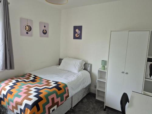 a bedroom with a bed and a white cabinet at 2 double bedroom house 20mins walk to Durham city centre in Gilesgate