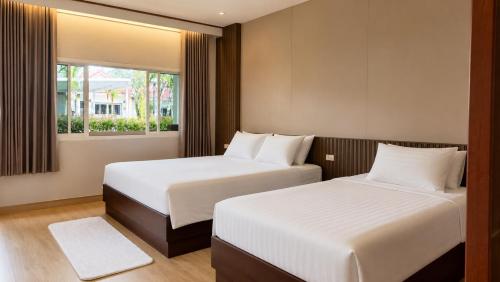 a bedroom with two beds and a window at Phuket Airport Villa in Phuket