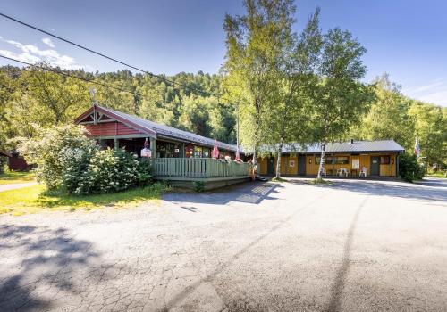 a large building with a porch and a house at Fauske Camping & Motel in Fauske