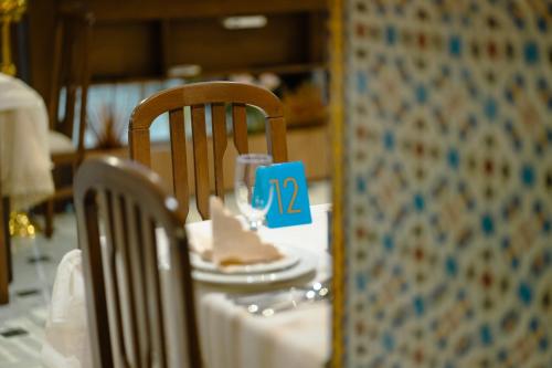 a table with a chair with a piece of cake on it at Hotel BouBabel in Nador
