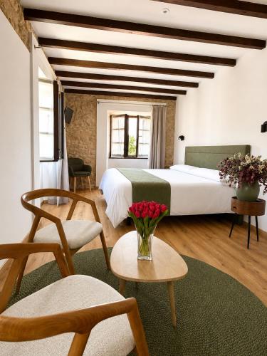a bedroom with a large bed with a vase of flowers at Hotel Restaurante Plati in Villarcayo