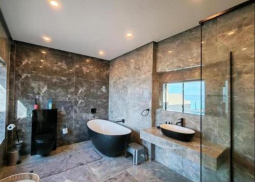 a bathroom with a large tub and a sink at Apartment 24 in Durban
