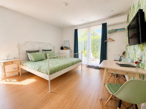 a bedroom with a bed and a desk with a computer at Luxury Suites Oosterwold in Almere
