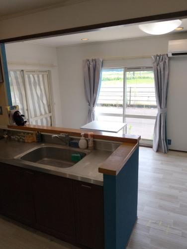 a kitchen with a sink and a large window at ゲストハウス紗乃葉 - Suzunoha in Bōchū