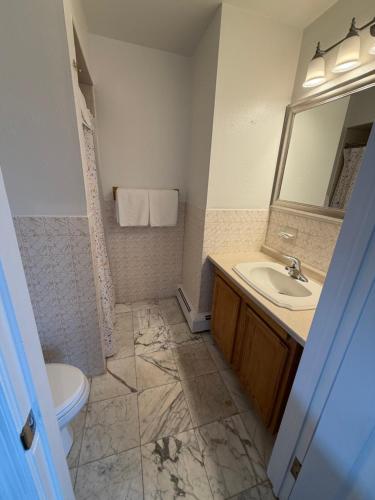 a bathroom with a sink and a toilet and a mirror at Atlantic Motel in Point Pleasant Beach