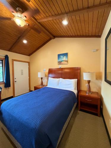 a bedroom with a blue bed with two night stands and two lamps at Atlantic Motel in Point Pleasant Beach