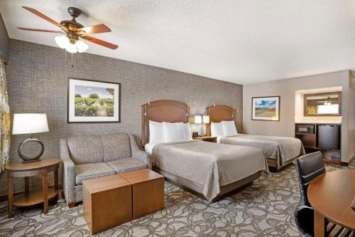 a hotel room with two beds and a couch and a table at Best Western Plus Black Oak in Paso Robles