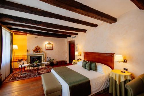 a bedroom with a bed and a fireplace at Romantic Hotel Furno in San Francesco al Campo