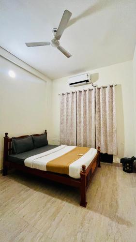 a bedroom with a bed with a ceiling fan at Maxi villa maamalla in Mahabalipuram