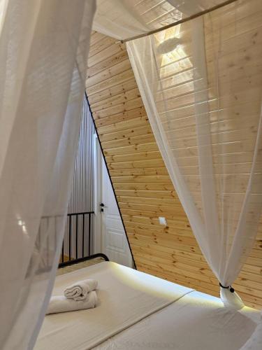 a bedroom with a bed with a curtain and a window at CottageNEO in Charnali