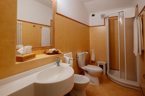 a bathroom with a sink and a toilet and a mirror at Romantic Hotel Furno in San Francesco al Campo