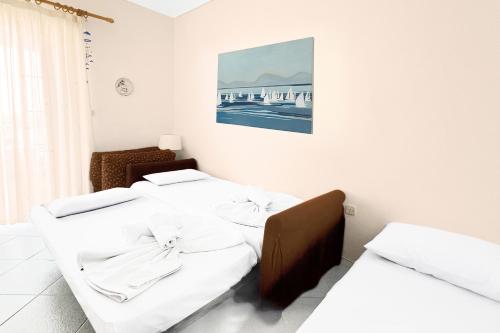 two beds in a room with white walls at Rona Vista Suites amazing seaview 3 in Polychrono