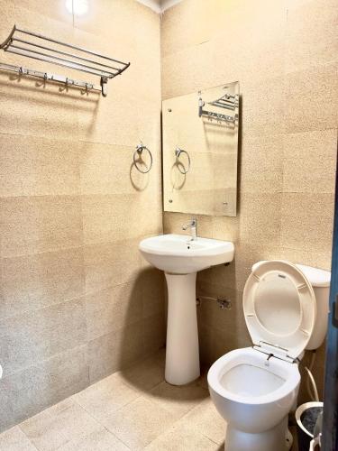 ein Badezimmer mit Toilette und Waschbecken in der Unterkunft Hotel De Agya in Ludhiana
