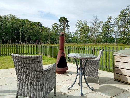 a patio with a table and chairs and a lighthouse at West Stable Cottage in Cameron