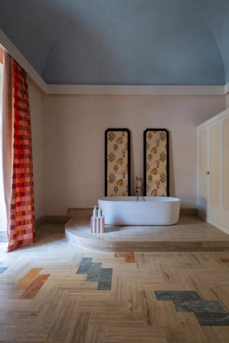 a bathroom with a white tub and two mirrors at EGEO - Ortigia in Syracuse