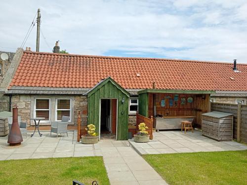 a backyard with a green shed and a table at West Stable Cottage in Cameron