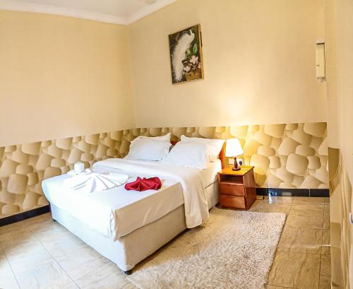 a bedroom with a bed with a red bow on it at Wenyeji Inn Hotel Moshi in Moshi