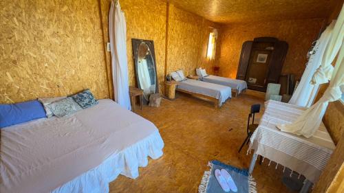 a room with two beds and a couch in it at Cap carav'ânes in Banī ‘Aţāʼ