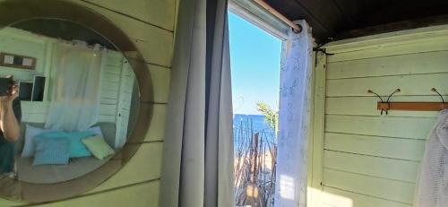 a mirror on a wall next to a window at Cap carav'ânes in Banī ‘Aţāʼ