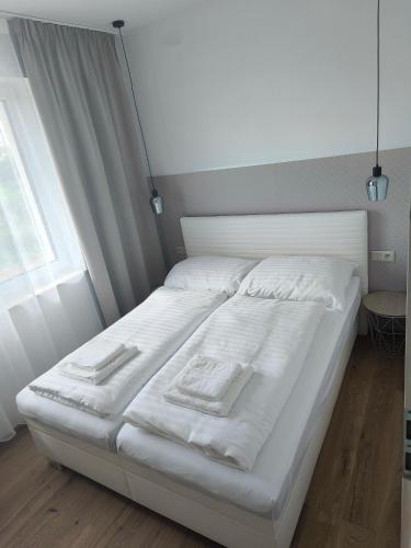 a white bed in a room with a window at Dubrowes cottage in Bobrów