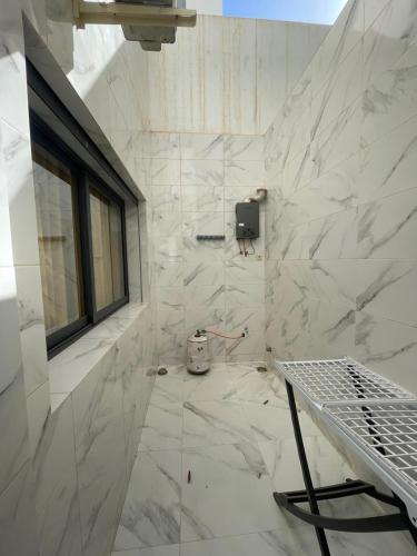 a bathroom with white marble walls and a window at Appartement direct aan zee in Azla-Tetouan in Azla