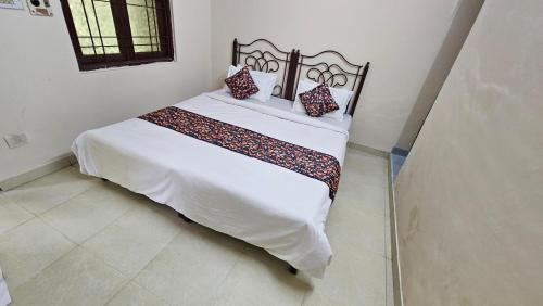 a bedroom with a white bed with two pillows on it at Value Stays By Amisha Palace in Jaipur