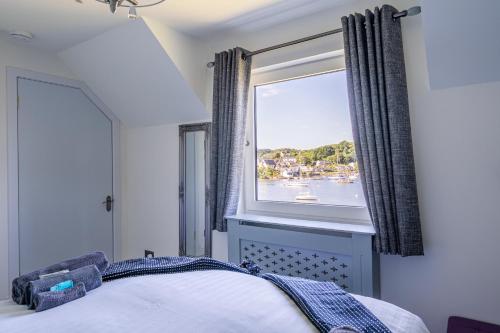 a bedroom with a window with a view of the water at Otterpoint Waterfront & Pool Retreat in Tayvallich