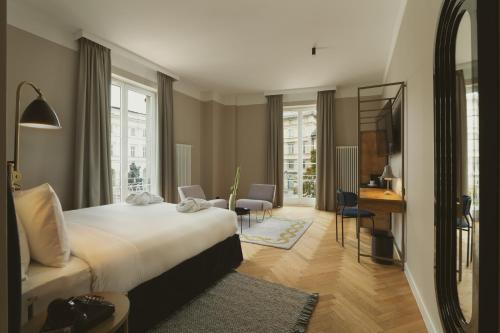 a hotel room with a large bed and a desk at Flaner Hotel, WorldHotels Crafted in Warsaw