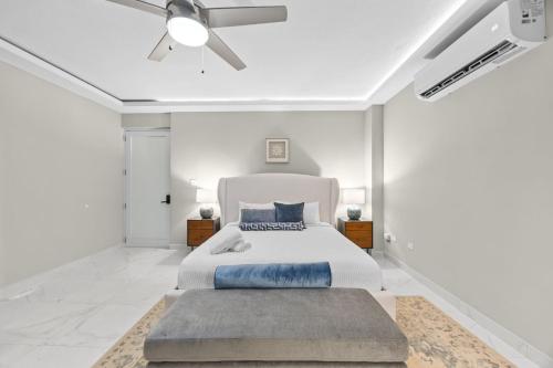 a white bedroom with a bed and a ceiling fan at Casa Lotus in San Juan
