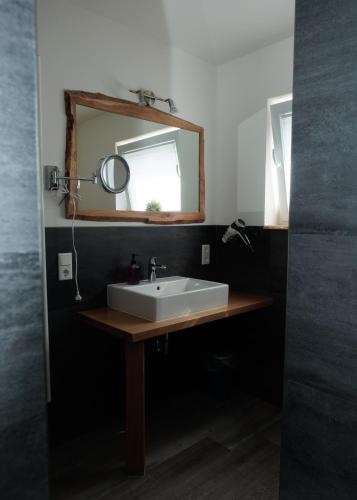 a bathroom with a white sink and a mirror at Auszeit an der Jümme in Detern