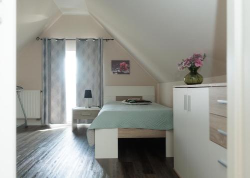 a bedroom with a bed with a green comforter at Auszeit an der Jümme in Detern