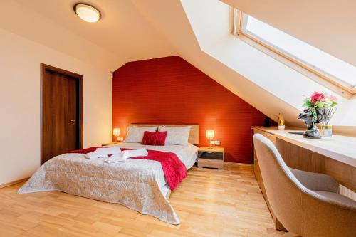 a bedroom with a bed with a red wall at CROSS SQUARE HOUSE - Spacious 2 Level Home, 2BR, 3Baths, Terrace - by RealTrust in Timişoara