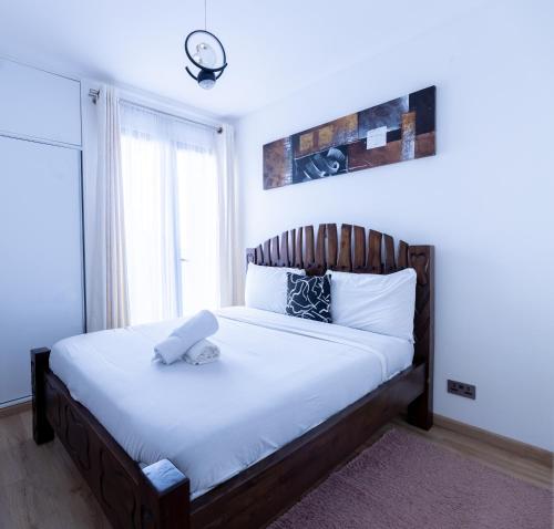 a bedroom with a large bed with white sheets at 1 bedroom unit with a sunrise view in Tatu City