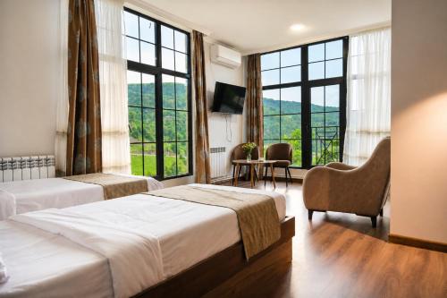 a hotel room with two beds and large windows at Madin Eco Hotel in Debed