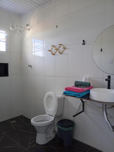 a bathroom with a toilet and a sink and a mirror at Pousada Fernandes in Três Corações