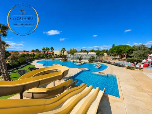 a pool at a resort with yellow slides at Le Tropical Mobil Home 6 Personnes - Plage à 200m - Parc Aquatique - Camping 5 Etoiles Les Dunes in Torreilles