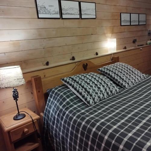 a bedroom with a bed and a wooden wall at Chalet La Bachole - Chambre d'hôtes in Charancieu