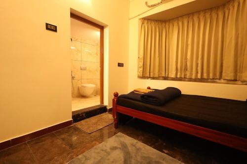 a bedroom with a bed and a bathroom with a shower at Princess Bungalow Stay Madurai in Tirupparangunram