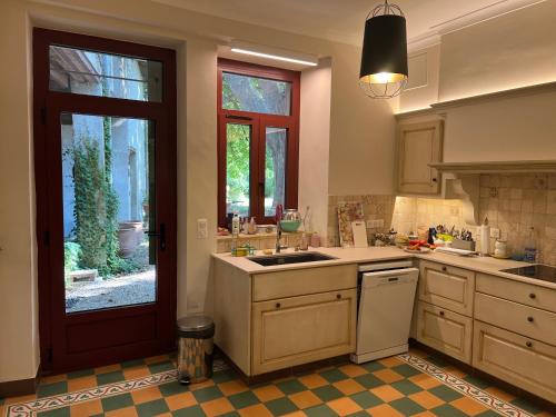 a kitchen with a sink and a door to a yard at Le Mas Ferrand in Graveson